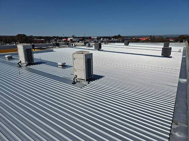 Commercial roof replacement Adelaide — crew installing new Colorbond roofing on an office building